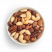 Mezcla de frutos secos tostados de almendras blanqueadas, almendras marrones naturales, avellanas, nueces pacanas y anacardos en un bol blanco sobre fondo blanco
