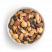 Mezcla de frutos secos Amor Portuario con pipas de calabaza, almendras blanqueadas, almendras marrones naturales, cacahuetes y macadamias en bol blanco sobre fondo blanco