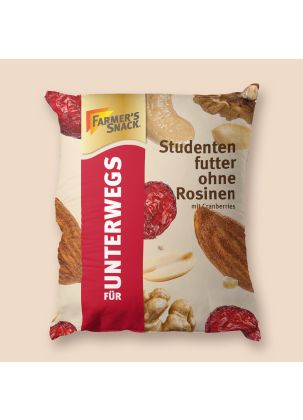 Puf en forma de bolsa con mezcla de frutos secos con arándanos rojos y sin pasas sultanas sobre fondo beige y logotipo Farmer's Snack